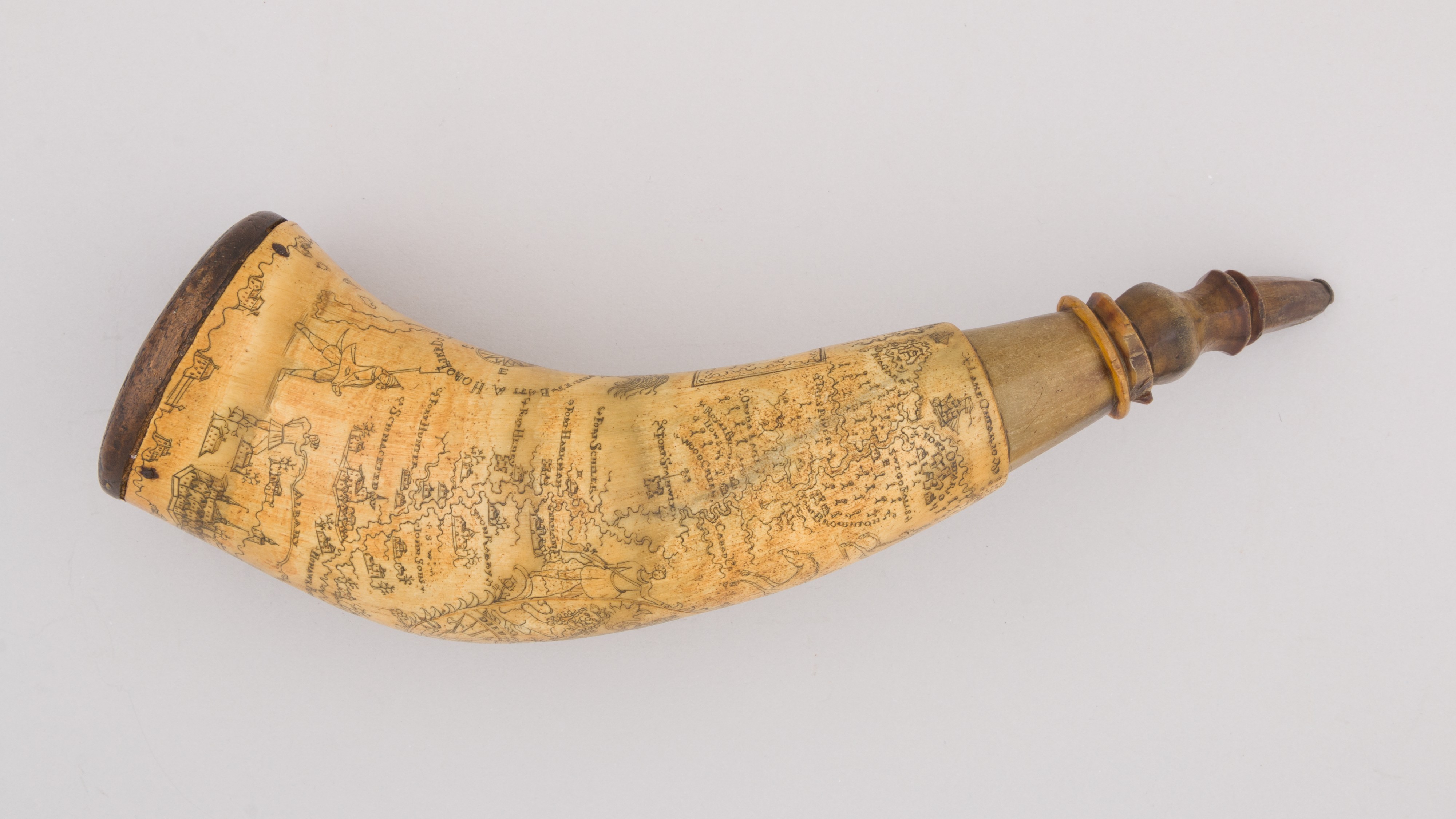 Polvorinho com gravura representando um mapa dos fortes e cidades ao longo dos rios Hudson e Mohawk, e as armas da Gr&atilde;-Bretanha/This powder horn is engraved with a map of forts and cities along the Hudson and Mohawk Rivers, and the arms of Great Britain, chifre de vaca, madeira, pigmento/horn (cow), wood, pigment, 31,4 cm. X &Oslash; 8.3 cm, 255.1 gr, 1763 &nbsp;